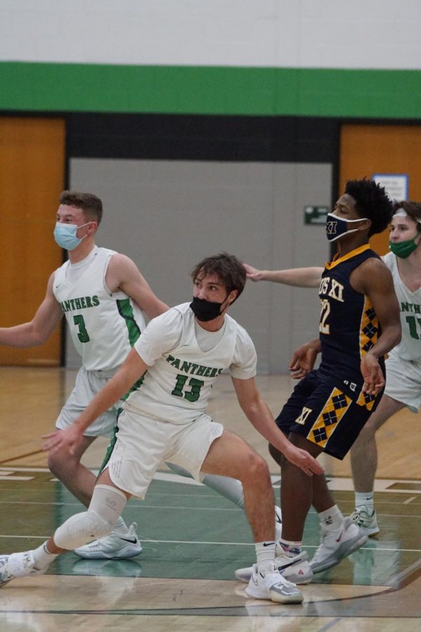 Junior Zack Sheridan (left) and senior Sam Sommerfeld (middle) in a game against Pius XI high school.